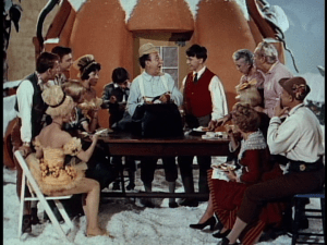 Ed Wynn (C) begins to entertain the various cast and crew members with props