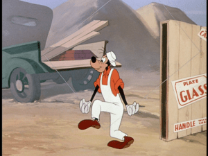 Goofy carefully carries a sheet of plate glass, with humorous results
