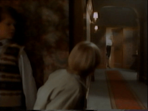 Two boys spy on Roberta around the corner of the hotel lobby