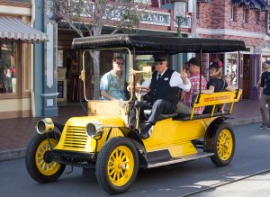 Take a ride in the yellow automobile. Or more appropriately, the Yellow Horseless Carriage. This vehicle, designed by Disney Legend Bob Gurr, first appeared on Main Street U.S.A. at Disneyland on December 6, 1956, and was the second of two Horseless Carriages to ride up and down the street carrying park guests. The first was the Red Horseless Carriage, which appeared May 12, 1956. The motorized Fire Engine appeared August 16, 1958. Prior to its appearance, there was a horse-drawn fire wagon that would carry park guests that debuted on the park's opening day, July 17, 1955. The fire wagon is now on permanent display inside the Disneyland Fire Department fire station.